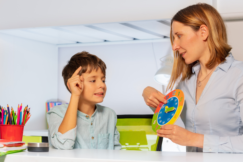 Boy,with,autism,spectrum,disorder,learn,clock,and,hours,,teacher